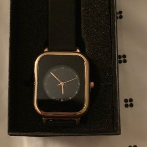 Womens wristwatch. Black and gold face. Band is rubber material.